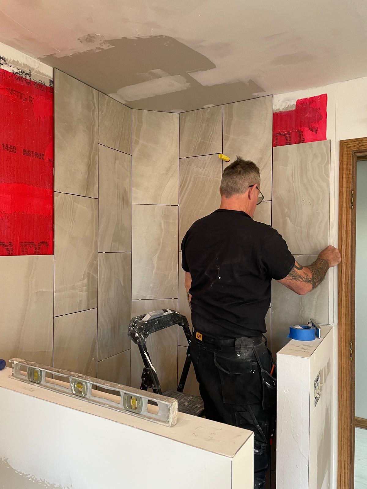 Rob installing large-format wall tile on a job site